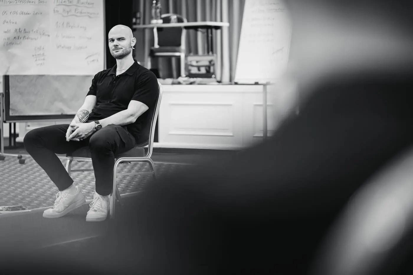 Fabian Schaub sitzt im Seminarraum vor Flipcharts