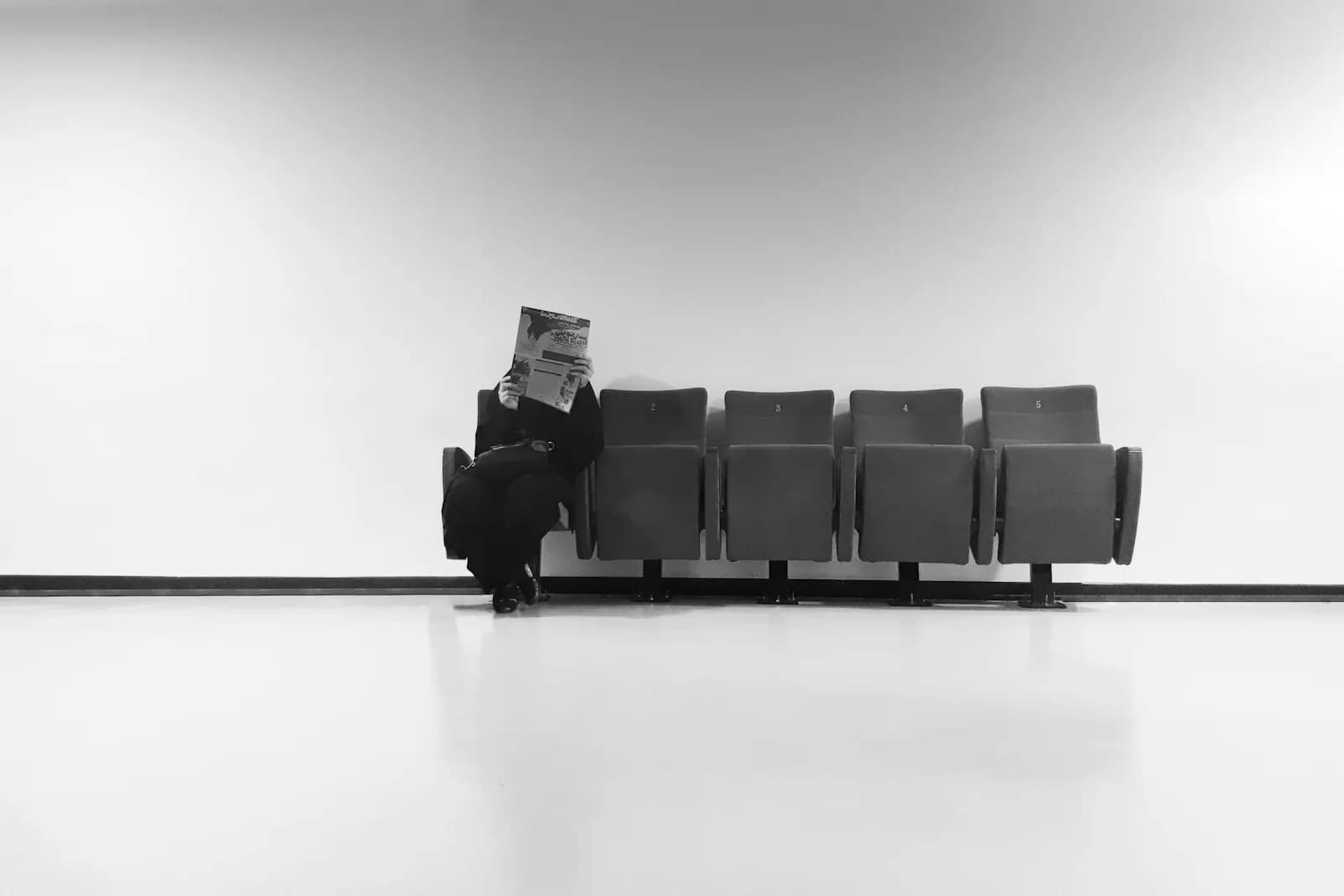 Ein Mann sitzt mit Abstand zu einem leeren zweiten Stuhl