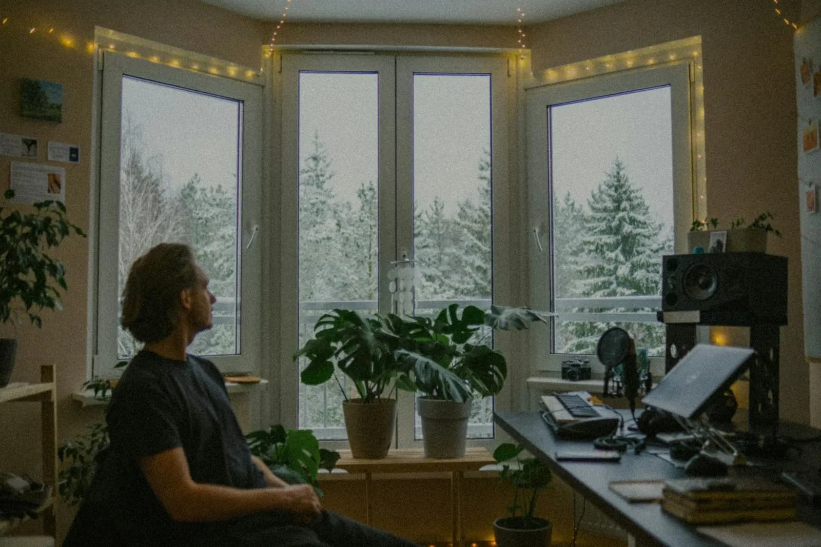 Ein Mann sitzt allein an einem Schreibtisch am Fenster