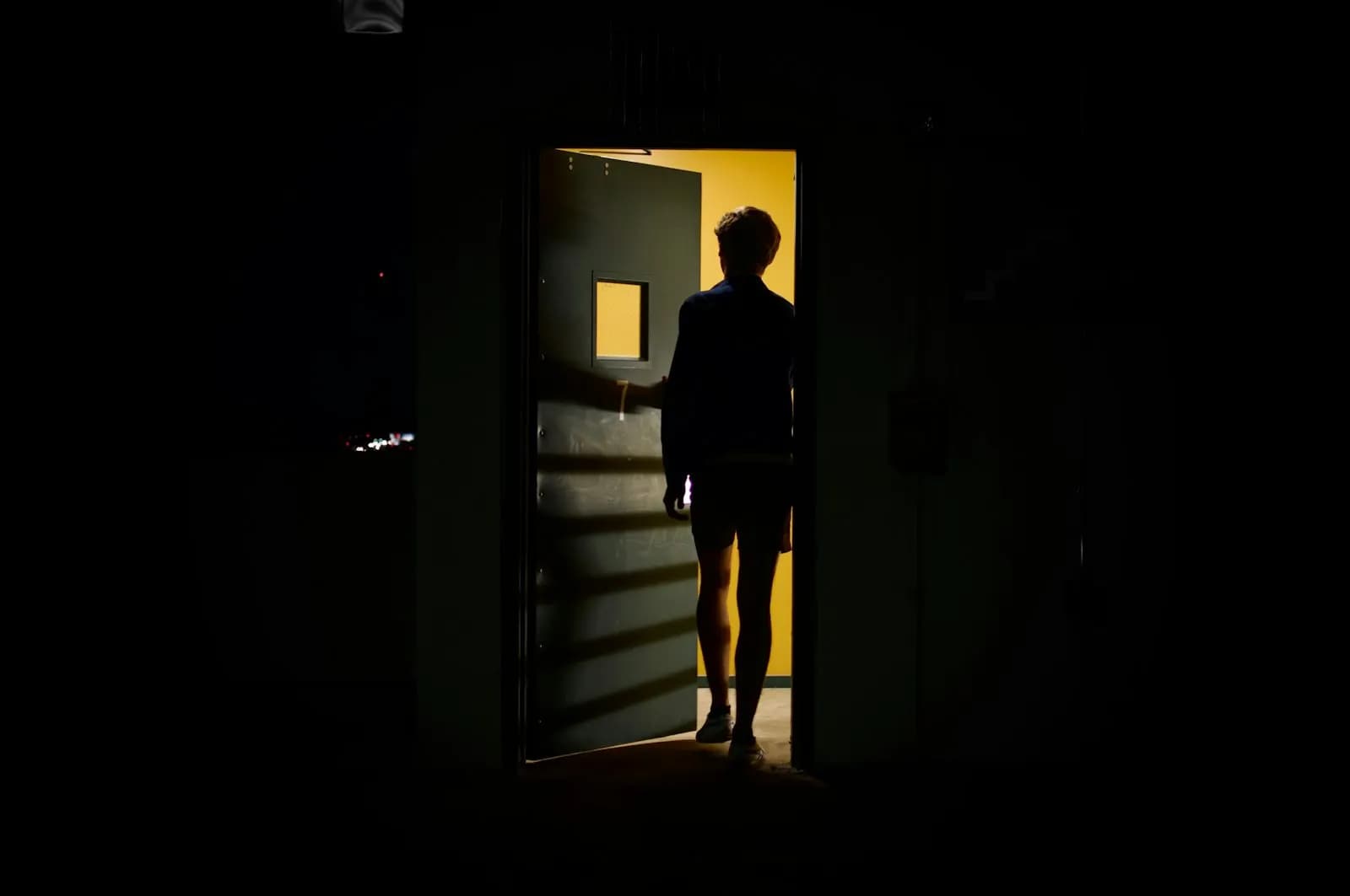 Ein Mann steht in einer offenen Tür und schaut nach draußen
