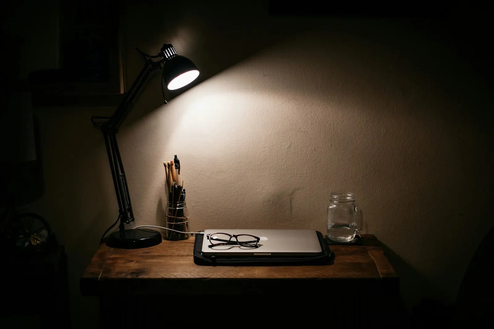 Handgeschriebene Notizzettel auf einem Schreibtisch unter einer Lampe, ohne Menschen im Bild.