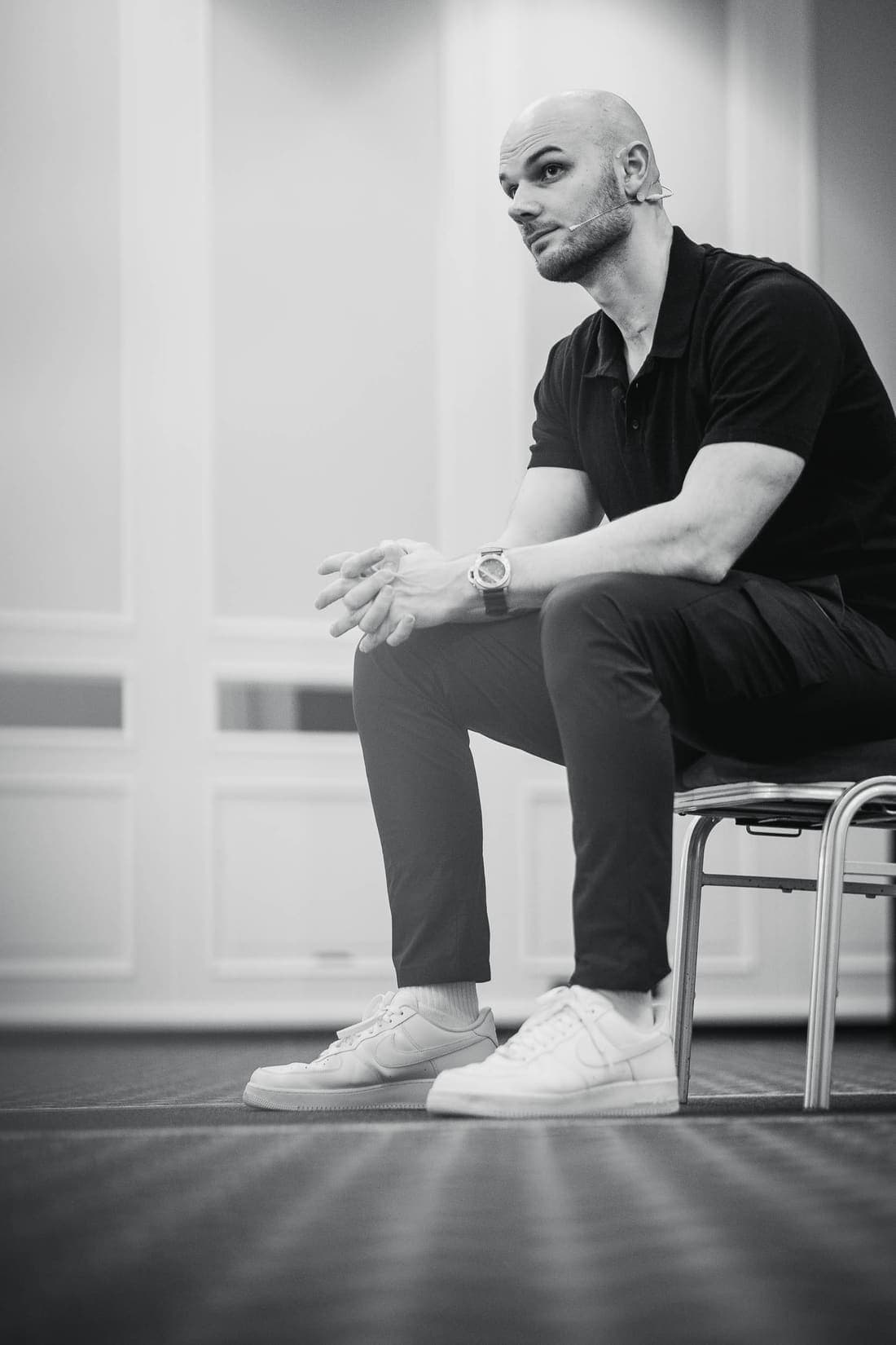 Fabian Schaub sitzt auf einem Stuhl, von der Seite, die Hände gefaltet, den Blick nach vorn