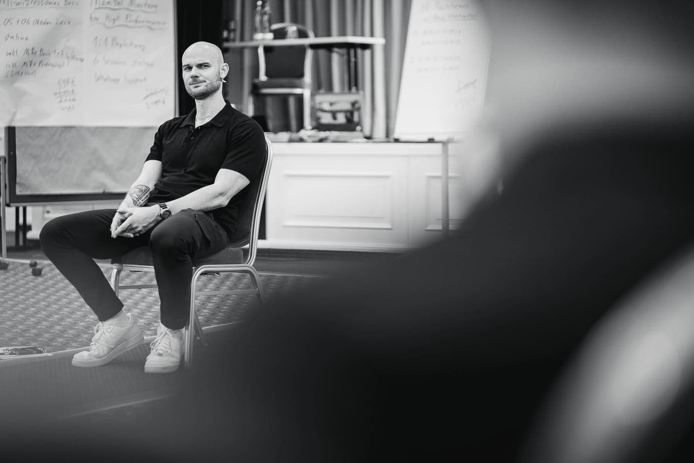Fabian Schaub sitzt im Seminarraum vor Flipcharts